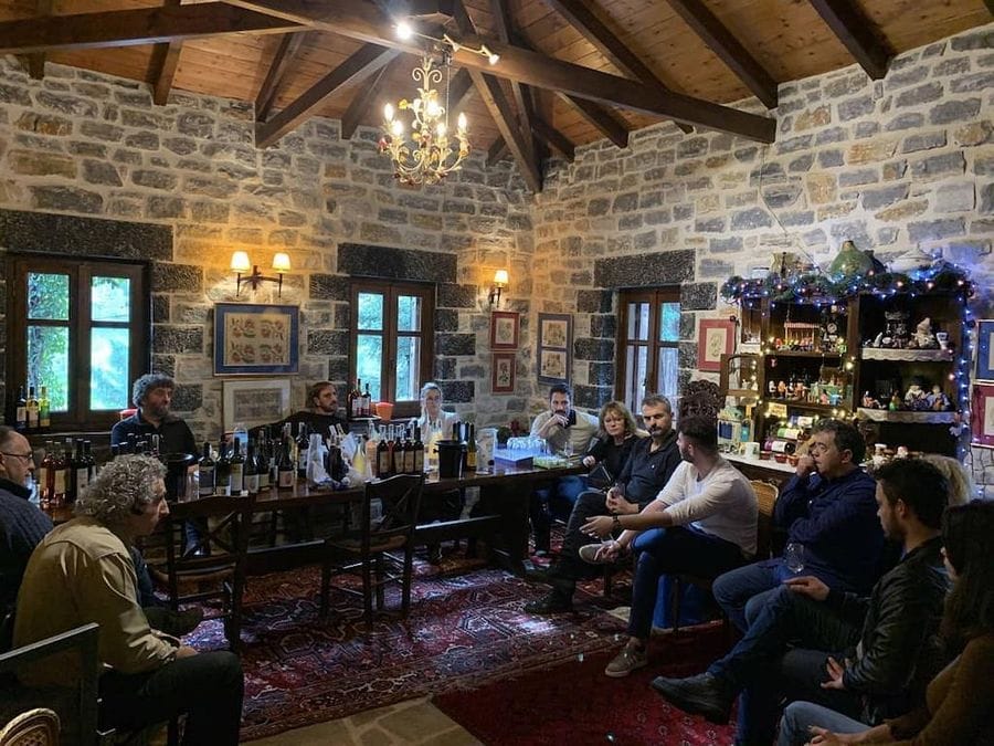 tourists smiling at the camera and holding glasses of wine for cheers and eating aperitifs at Kalogris Organic Winery
